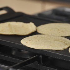 Poner las tortillas a tostar sobre el comal a fuego lento hasta que queden crujientes pero no quemadas.