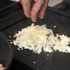 Colocar un poco de aceite sobre un comal caliente, agregar pequeñas porciones de queso del tamaño de las tortillas.