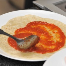 Colocar las tortillas en otro plato y por un sólo lado poner la salsa de tomate con una cuchara.