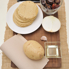 20 tortillas taqueras 20 chile cascabel 1 diente de ajo ½ cebolla 1 papa grande Aceite de canola, al gusto Bolsa de plástico Papel estraza Guisos varios: chicharrón en salsa roja, frijoles refritos con chorizo, papas con chorizo