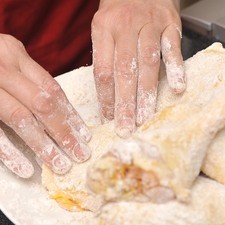Extender la harina sobre un plato y revolcar cada pieza de pollo sobre ella. Sacudir el exceso.