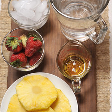 1 y ½ litros de agua 6 fresas 4 rebanadas de piña ¼ de taza de miel de agave Desinfectante de verduras Hielo al gusto