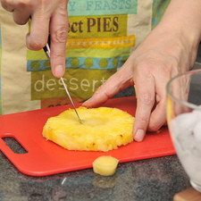 Pelar la piña con un cuchillo, cortarla en rebanadas. Removerle el centro fibroso con la ayuda de un vaso tequilero o un cortador de galletas.