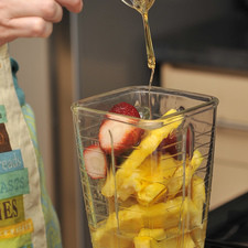 Licuar cuatro rebanadas de la piña con las fresas, la miel y una parte del agua. Se puede endulzar con azúcar si no se consigue la miel de agave.