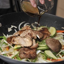 Agregar la calabacita y los hongos remojados y escurridos. Aderezar con la mezcla de la salsa de soya, el azúcar, agua y Ponzu. Cocer cinco minutos más hasta que los vegetales estén cocidos.