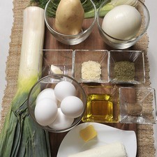 1 cucharada de mantequilla 1 papa 1 diente de ajo 1 cebolla 1 poro 1 bulbo de hinojo 6 huevos 150 gramos de queso de cabra 2 cucharadas de eneldo 1 cucharadas de queso parmesano rallado Aceite de oliva al gusto Sal al gusto Pimienta al gusto