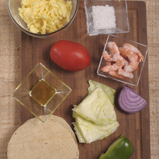 9 camarón pacotilla 60 gramos de queso Gouda Aceite de oliva al gusto Sal de mar al gusto 1 trozo de lechuga Salsa Huichol al gusto 6 tortillas amarillas ¼ de cebolla morada 1 jitomate guaje 1 limón Aceite de oliva al gusto