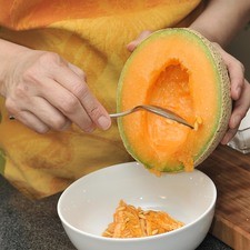 Retirar las semillas del melón con una cuchara. Reservarlas por si se quiere hacer horchata de semillas de melón.