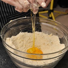 Una vez que se tiene una mezcla uniforme, agregar el azúcar y mezclar con las manos nuevamente. Añadir los huevos y comenzar a incorporar.
