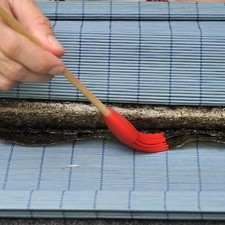 Mojar el final del alga con un poco de agua usando una brocha para que se pegue y terminar de enrollar.