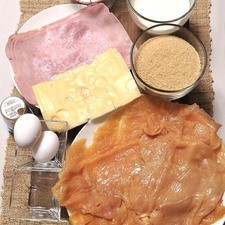 4 milanesas de pollo Sal al gusto Pimienta al gusto 4 rebanadas de queso gruyere 4 rebanadas de Jamón de puerco 1 ½ tazas de Harina 2 Huevos 1 taza Leche 2 tazas Pan molido Aceite vegetal Palillos de madera