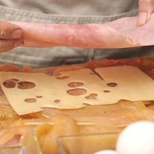 Colocar una rebanada de queso y una de jamón en el centro de cada milanesa.