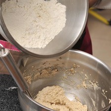 Agregar poco a poco los ingredientes secos a la mezcla cremosa e incorporar utilizando una espátula con un movimiento envolvente hasta que la mezcla se vea homogénea.