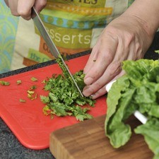 Enjuagar las espinacas, la hierbabuena y el perejil en agua limpia. Picar la lechuga en trozos grandes. Poner todo esto a remojar en un tazón con agua y una gota de desinfectante durante 5 minutos. Escurrir todas las hojas verdes. Colocar la lechuga en un platón, sobre ella la espinaca, los berros y la hierbabuena el perejil picados.