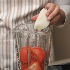 Para preparar la salsa roja, moler el jitomate junto con el trozo de cebolla y el diente de ajo en la licuadora.