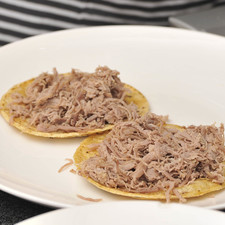 En una sartén abierta, colocar aceite vegetal y dejar calentar, pasar las tortillas por el aceite caliente hasta que se suavicen. Colocarlas en un plato para servir. Colocar la carne deshebrada sobre las tortillas.