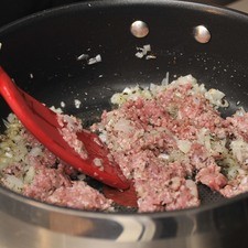 Añadir la carne molida, desbaratar bien con una pala y continuar cociendo hasta que ya no se vea rosa.