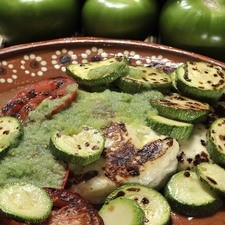 Servir el queso y las verduras calientes bañados con la salsa cruda de tomate verde.