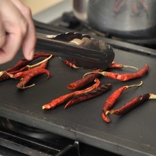 Poner a tostar los chiles sobre el comal, dando vuelta con una pinza hasta que se vean tostados pero no quemados.