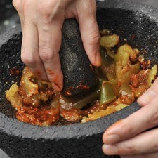 Moler el ajo en trozos junto con los chiles de árbol en el molcajete. Agregar lso tomates escalfados y moler para que quede una salsa martajada. Sazonar con sal. Si se deja reposar toma un sabor más sabroso e intenso.