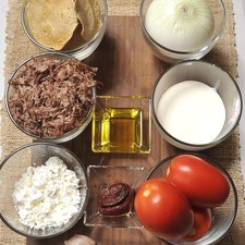 300 gramos de carne deshebrada de res 4 jitomates 2 chile chipotle adobado 1 diente de ajo 1 cebolla Sal al gusto Aceite de oliva, la gusto Queso doble crema, al gusto Crema de leche de vaca, al gusto