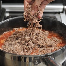 Añadir la carne deshebrada, sazonar con sal al gusto y dejar cociendo 5 minutos más. Servir la carne sobre las tostadas. Montar sobre ella un chopito de crema y espolvorear queso al gusto.