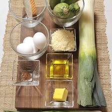 3 piezas de Huevo 1 trozo de Poro 1/4 cucharada de Nuez moscada Aceite de oliva al gusto Queso parmesano al gusto 1 rebanada de Pan blanco Sal al gusto 1/4 barra de Mantequilla 2 piezas de Cebollitas de cambray 4 piezas de Calabacita