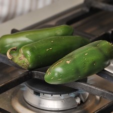 Para pelar y desvenar los chiles, si se consiguen chiles poblanos queda mejor, en este caso se utilizarían 6 para esta receta. De lo contrario, asar los chiles jalapeños sobre la hornilla de la estufa hasta que la piel esté negra. Espolvorear con sal de mar y colocarlos en una bolsa de plástico para que se suden durante 5 minutos.