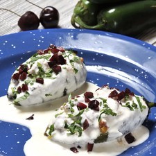 Servir bañados con la nogada fría. Espolvorear con el resto del perejil picado y cerezas picadas.