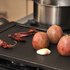 Tostar los xoconostles, los chiles y el ajo sobre el comal a lumbre media, dándoles vuelta de vez en cuando con una pinza hasta que adquieran una piel tostada.