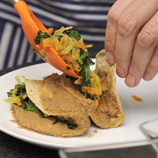 Calentar las tortillas. Pasarlas por la salsa. Rellenarlas con las verduras.