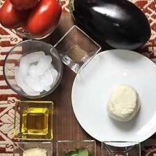 6 jitomates guaje 1 diente de ajo 6 hojas Albahaca fresca 1 berenjena grande 250 g de queso Mozzarella 2 cucharadas de queso parmesano Aceite de oliva Sal Pimienta Hielo