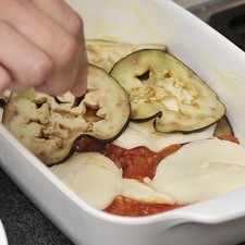 En un refractario adecuado para horno, intercalar la berenjena con la salsa de jitomate y el queso Mozzarella en rodajas.