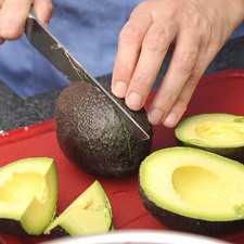 Cortar los aguacates por la mitad, girar y separar las mitades. Colocarla mitad que tiene el hueso sobre la mesa y ensartar el cuchillo sobre el hueso, girar para retirarlo. S 3446 1475630845