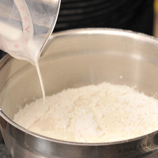 Agregar la manteca, la leche y la vainilla y mezclar con la batidora eléctrica durante un minuto aproximadamente a velocidad media, hasta que la mezcla se vea homogénea. Parar de batir y bajar la mezcla que pueda estar pegada en los lados del tazón, utilizando la pala miserable.