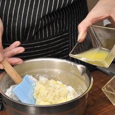 Para preparar el betún: Mientras se hornean los bollitos, colocar el azúcar pulverizada, 1/8 de cucharadita de sal, la ralladura de cáscara de naranja, la mantequilla que se ha dejado suavizar un poco y sólo dos cucharadas de jugo de naranja en un tazón limpio. Revuelva utilizando una pala miserable. Si la mezcla queda muy espesa, agregue un poco más de jugo de naranja.