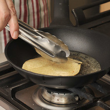 Poner a calentar aceite en un sartén pequeño. Con ayuda de una pinza, pasar las tortillas brevemente por el aceite para que se suavicen. Reservar sobre un plato.