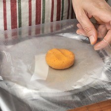 Hacer bolitas con la masa roja y aplastarlas con la máquina para tortillas.
