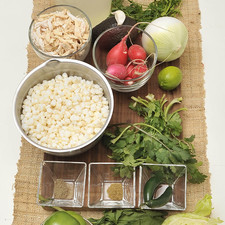 1 kilo de maíz pozolero pre cocido 1 pechuga de pollo cocido y desmenuzado 2 litros de caldo de pollo 8 tomates verdes 2 chiles serranos ½ manojo de hojas de cilantro ½ manojo de hojas de perejil 3 ramas de epazote 1 cebolla ½ en trozo y ½ picada 1 diente de ajo ¼ de cucharadita de pimienta en polvo ¼ de cucharadita de comino en polvo Sal al gusto 7 rabanitos lavados, desinfectados y cortados en rodajas 7 hojas de lechuga desinfectada y picada Orégano triturado al gusto 1 aguacate grande rebanado (300 g) 1 limón