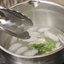 Colocar inmediatamente las puntas de los espárragos en agua con hielo para evitar que se sigan cocinando y reservar. Moler en la licuadora las partes medias ya cocidas con el caldo de pollo y el ajo pelado.
