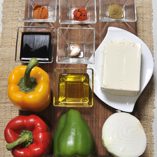 Ingredientes: Sal Aceite de oliva 1 pieza de Pimiento verde 1 pieza de Pimiento amarillo 1/2 pieza de Cebolla blanca 5 cucharadas de Salsa de soya 1 diente de Ajo 1 cucharita de Paprika 1/2 cucharita de Comino en polvo 1 cucharita de Pimienta de cayena 1 pieza de Pimiento rojo 500 gramos de Tofu extra firme