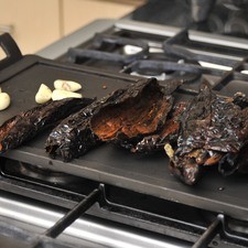 Desvenar los chiles, tostar sobre un comal junto con el ajo.