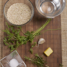 2 ½ tazas de agua 1 cucharada de mantequilla ½ cucharita de romero ½ cucharita de tomillo 1 cucharita de sal 1 taza de arroz 1 cucharada de perejil 1 diente de ajo Papel aluminio
