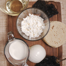 ½ cebolla 2 cucharadas de vinagre blanco 2 chiles anchos 2 chiles mulatos 12 tortillas chicas ½ taza de crema 1 taza de queso fresco ½ taza de aceite de canola Sal al gusto