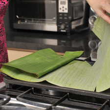 Calentar las hojas de plátano sobre el comal para que se tornen flexibles.