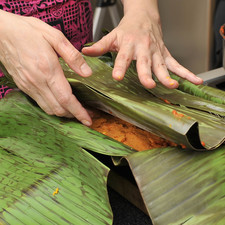Envolver toda la masa con la primera hoja de plátano.