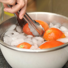Sacar los jitomates, con una pinza ponerlos en agua con hielo.