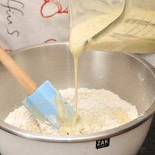 Verter la mezcla de plátanos sobre los ingredientes cernidos. Revolver bien con la pala miserable hasta que se deshagan todos los grumos. S 3900 1475629924