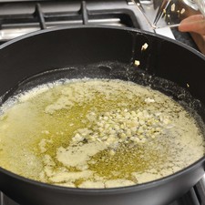 Para preparar la salsa, derretir la mantequilla en una sartén a fuego medio, agregar el diente de ajo finamente picado y cocer un minuto.