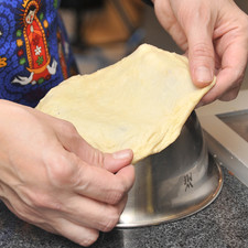 Formar bolitas de masa del tamaño de una pelote de golf. Estirar las bolitas utilizando un tazón volteado al revés. Anteriormente se estiraban sobre la rodilla. Colocar las tortillas sobre un trapo.